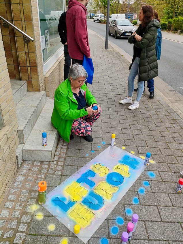Bild aus Kreide auf dem Bürgersteig mit dem Text. "Let's Europe" Daneben stehen Spraydosen